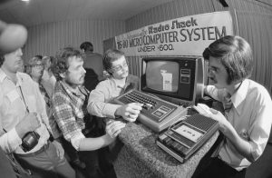 Radio Shack’s Micro Computer System, uses their computer keyboard into regular home TV set and programmed by tape cassette on home cassette player at Boston Computer show on August 25, 1977. Left to right: visitors Robert Lundgren of Des Plaines, Ill.; Malcolm MacLeod of Montreal; and Radio Shack salesman Steven Carlozzi of Brockton, Mass. (AP Photo/CM)